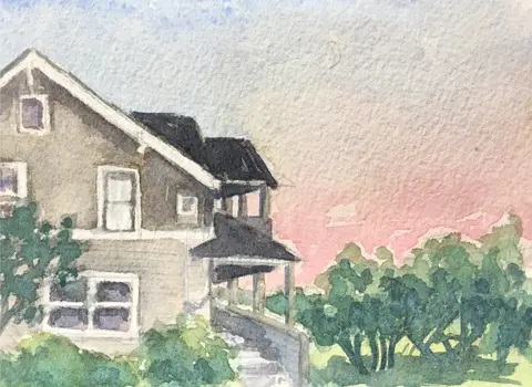 Watercolor painting of a house with a sloped roof and porch, surrounded by bushes, with a pinkish sky in the background.