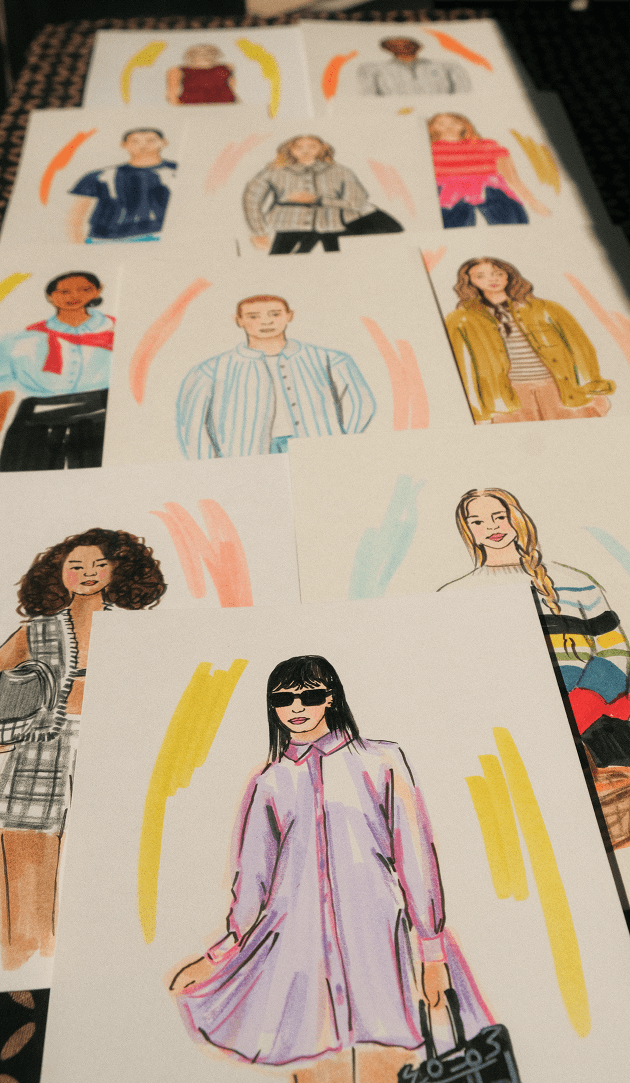 Colorful guest fashion portraits spread across a patterned table